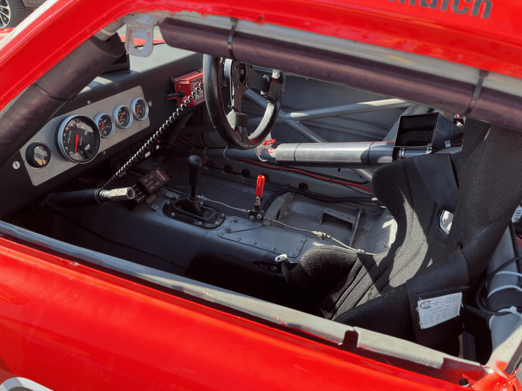 Interior view of a Z car, showcasing the dashboard with various gauges, a racing steering wheel, and a racing seat.