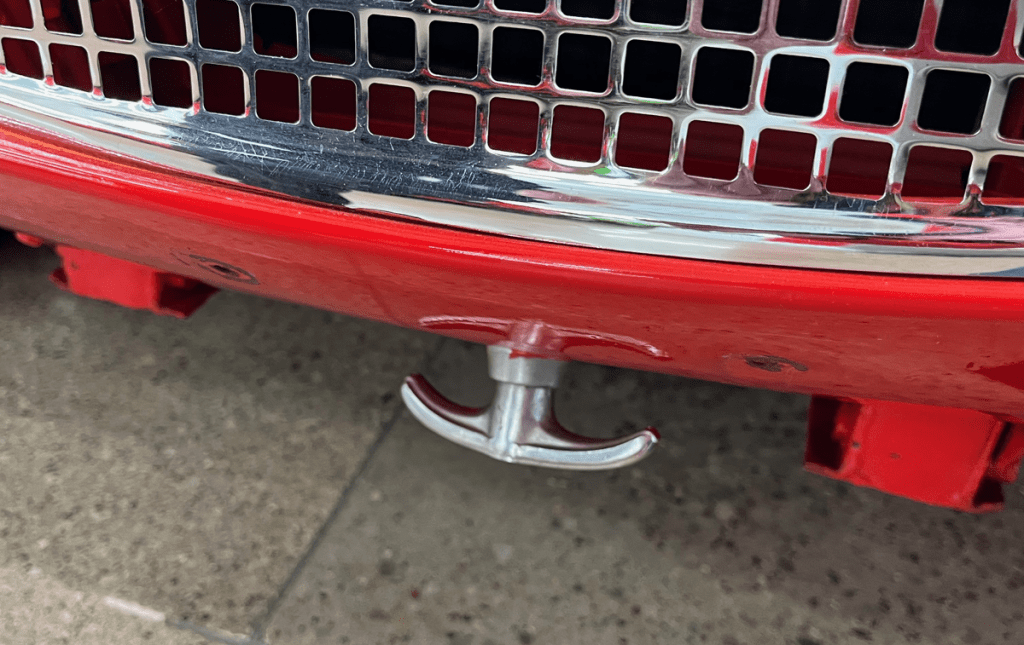Close-up of the front grille and hook of a vintage 1958 Austin Healey Bug Eye Sprite, showcasing its chrome detailing.