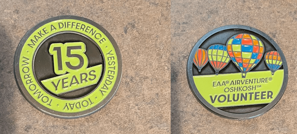 A commemorative challenge coin celebrating 15 years of volunteering at EAA AirVenture Oshkosh, featuring the text '15 YEARS' and colorful hot air balloons.