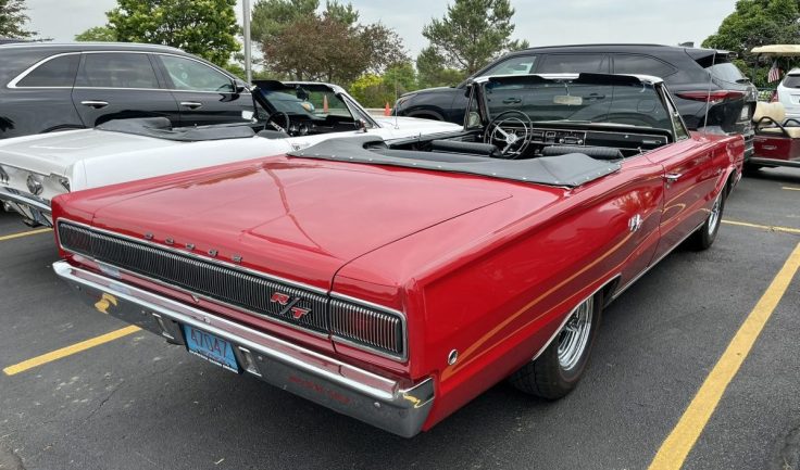 Rear view of a red 1967 Dodge Coronet R/T Convertible parked in a lot, showcasing its classic design and styling.