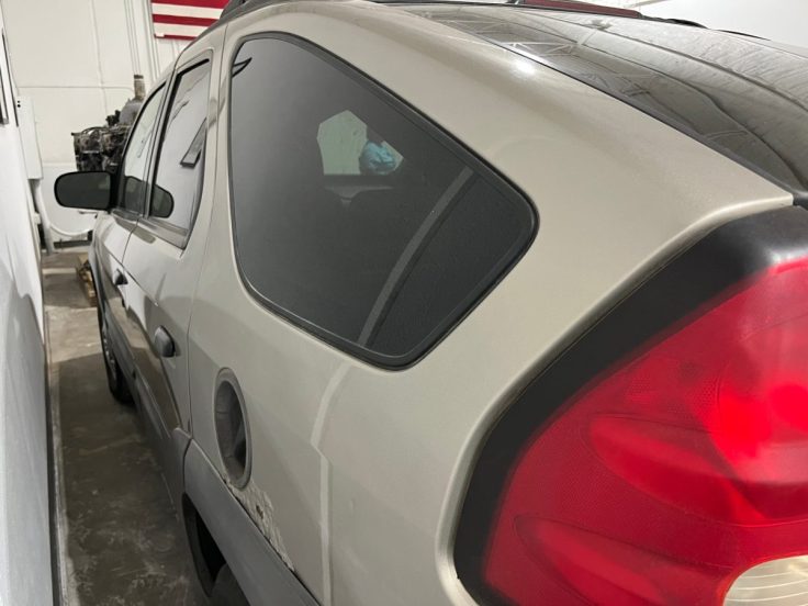 Close-up view of the rear side of a Pontiac Aztek, showcasing its unique design features and rear lights.
