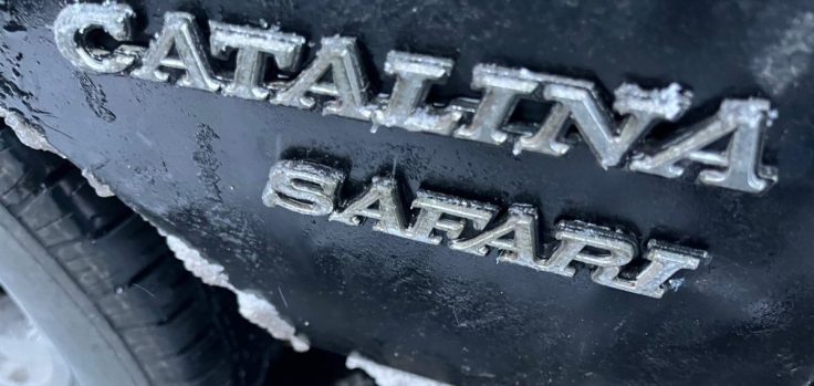 Close-up of the 'Catalina Safari' emblem on a vehicle, partially covered in frost.