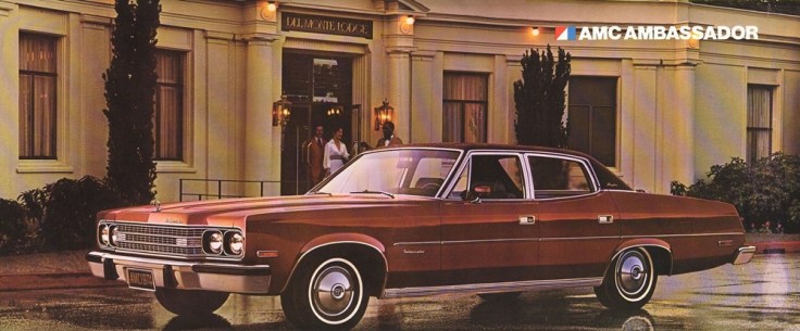 A vintage AMC Ambassador parked outside a stylish building with large windows and a welcoming entrance.